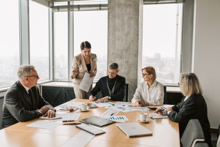 Empresários avaliando propostas de empresas de consultoria empresarial durante reunião
