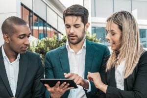Empresários analisando dados em tablet, discutindo contabilidade fiscal, financeira e gerencial