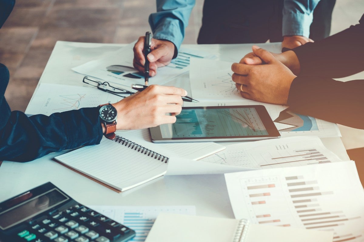 Equipe analisando relatórios e gráficos de contabilidade gerencial em reunião estratégica