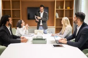 Consultor contábil apresentando estratégias a empresários durante reunião