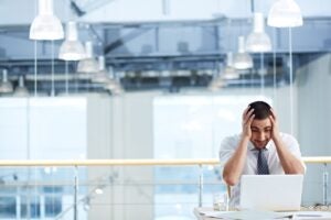Empresário preocupado com erros de contabilidade diante do notebook