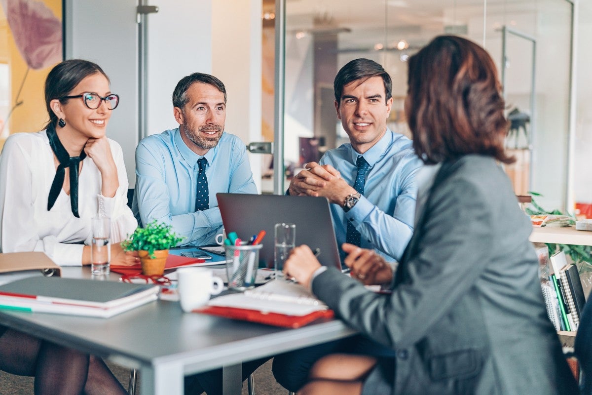 Equipe de consultores em reunião estratégica com gestores empresariais