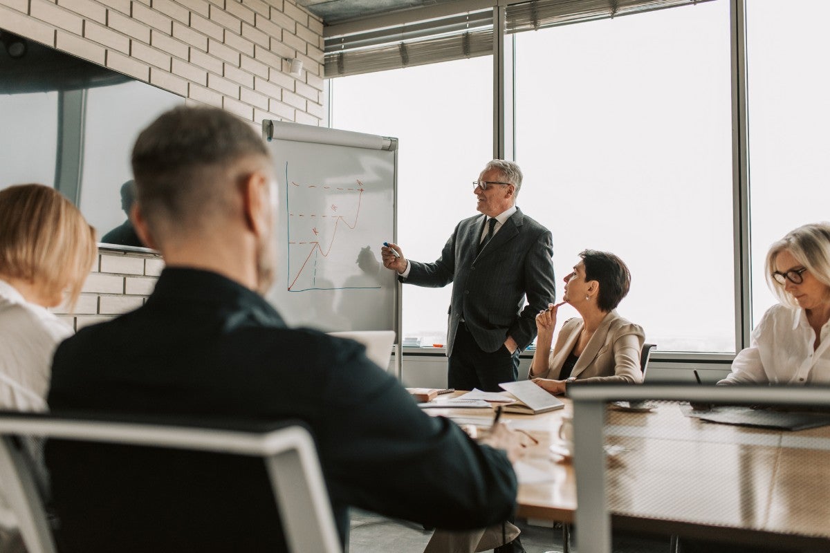 Consultores empresariais analisando estratégias de gestão em reunião corporativa