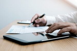 Auditor independente analisando demonstrações contábeis para emitir uma avaliação imparcial.